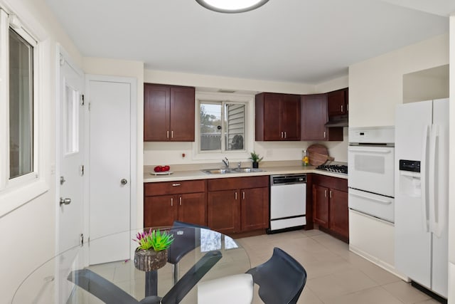 kitchen with light tile patterned flooring, white appliances, and sink