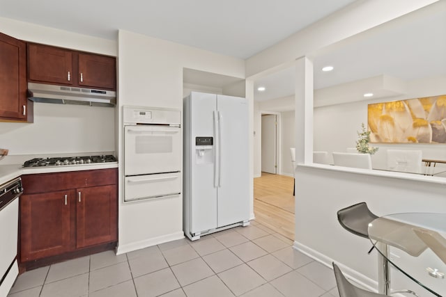 kitchen featuring light tile patterned flooring and white appliances