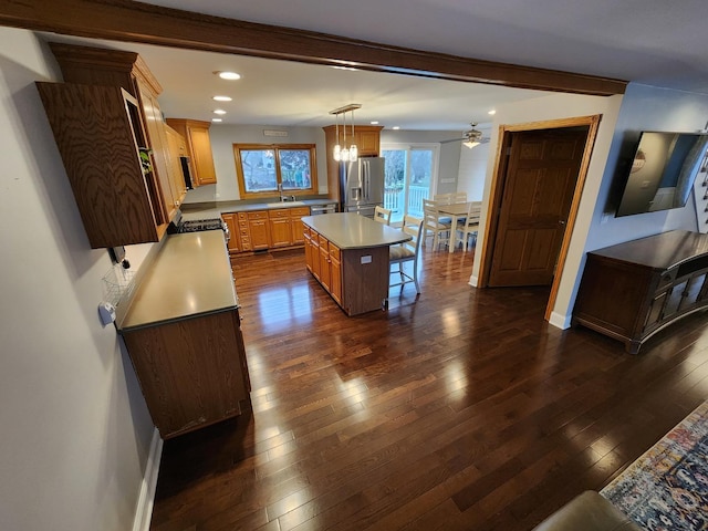 kitchen with decorative light fixtures, a center island, stainless steel appliances, and dark hardwood / wood-style floors