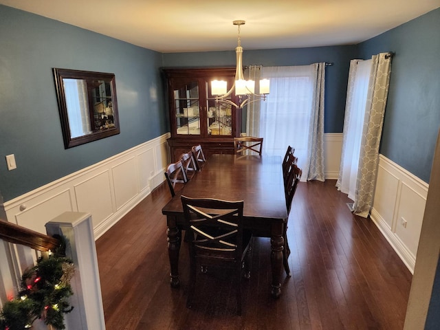 dining area with dark hardwood / wood-style flooring and a chandelier