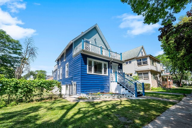 view of front of property with a balcony and a front lawn