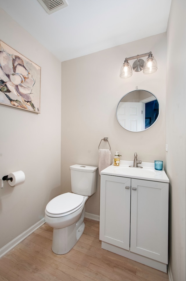 bathroom featuring vanity, hardwood / wood-style flooring, and toilet