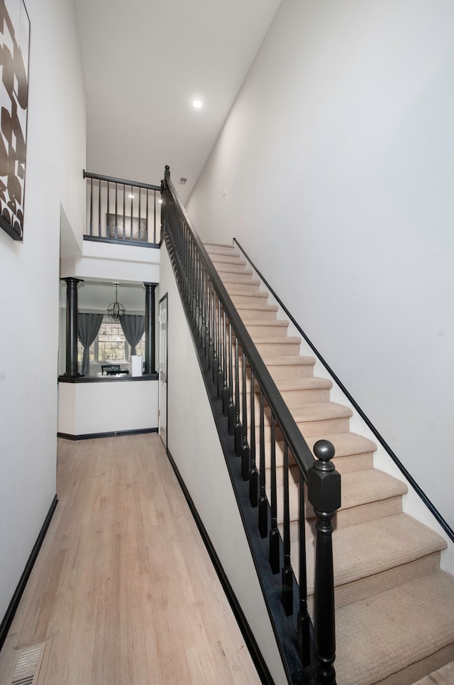 stairway featuring a high ceiling and hardwood / wood-style flooring