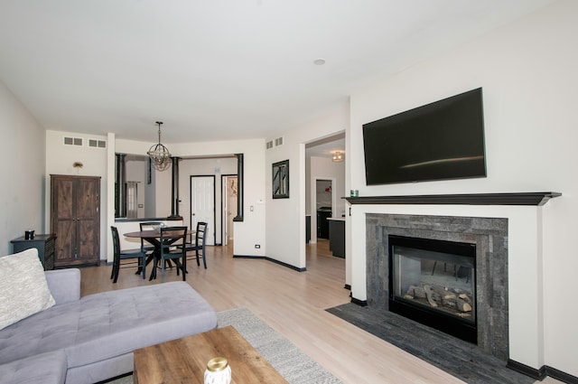 living room with light hardwood / wood-style flooring and a notable chandelier