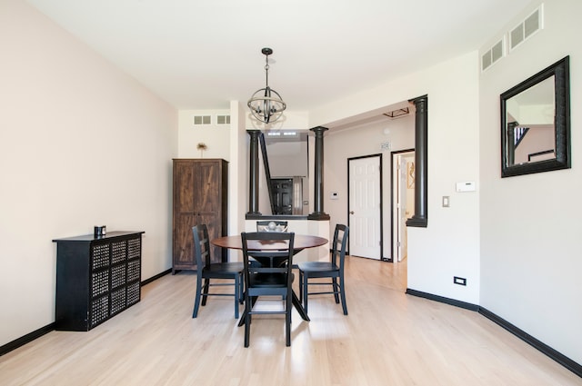 dining space featuring light hardwood / wood-style flooring and a notable chandelier