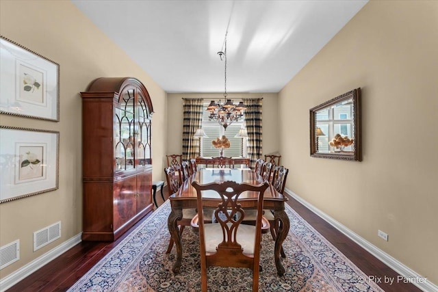 dining area featuring dark hardwood / wood-style flooring and a chandelier