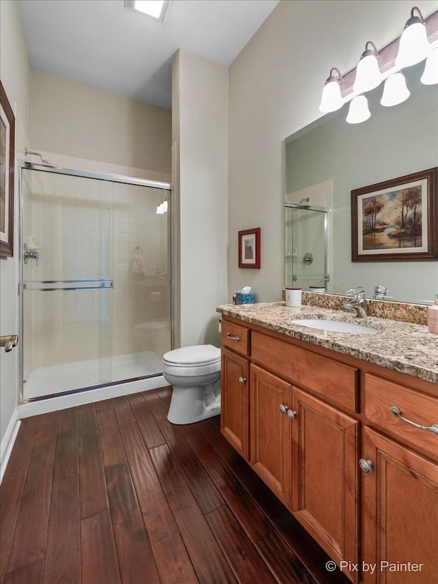 bathroom with vanity, toilet, and a shower with door