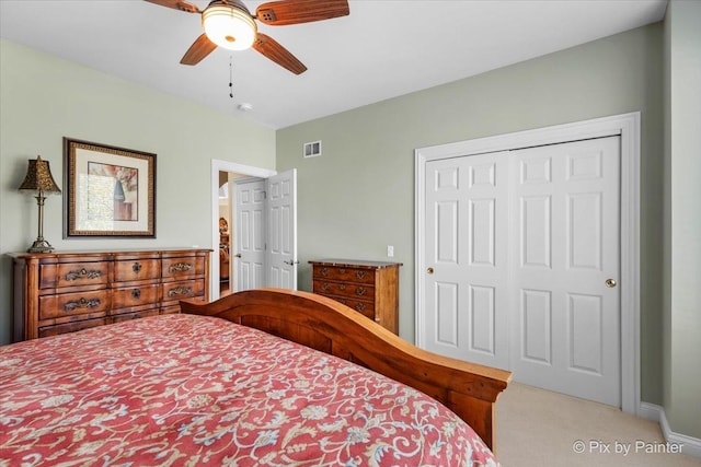 carpeted bedroom with ceiling fan and a closet