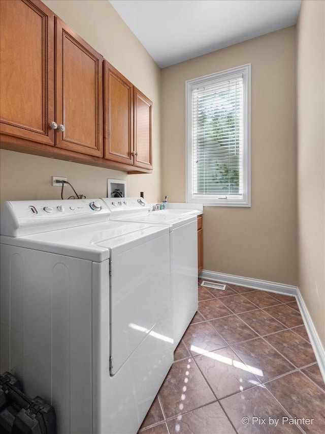 laundry area featuring dark tile patterned flooring, cabinets, and independent washer and dryer