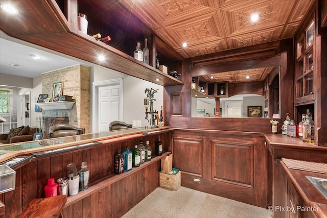 bar with a fireplace and carpet floors