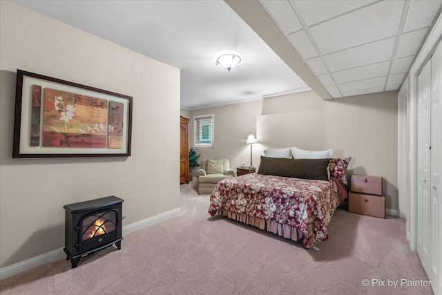 carpeted bedroom with a closet and a drop ceiling