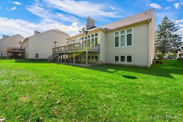 rear view of property with a lawn and a wooden deck