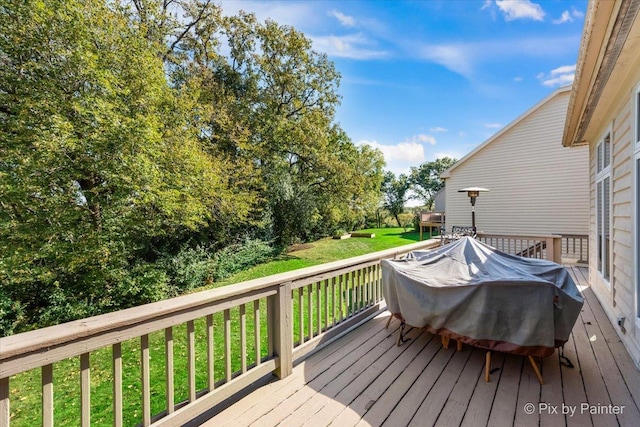 wooden deck featuring a lawn