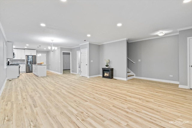 unfurnished living room with ornamental molding and light hardwood / wood-style flooring