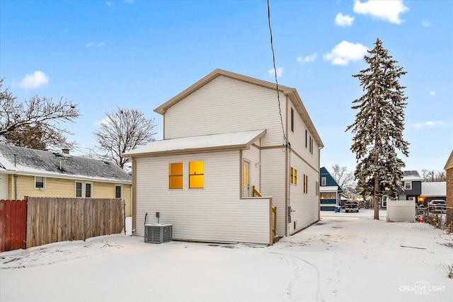 snow covered property with cooling unit