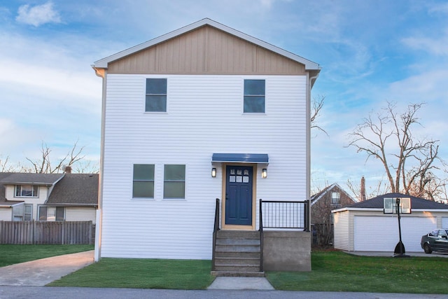 front facade featuring a garage, a front lawn, and an outdoor structure