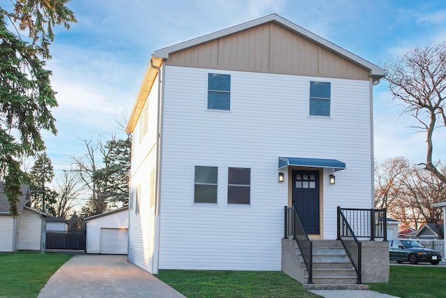 view of front of home with an outbuilding, a front yard, and a garage