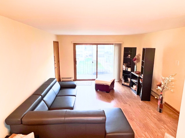 living room featuring a baseboard heating unit and light wood-type flooring