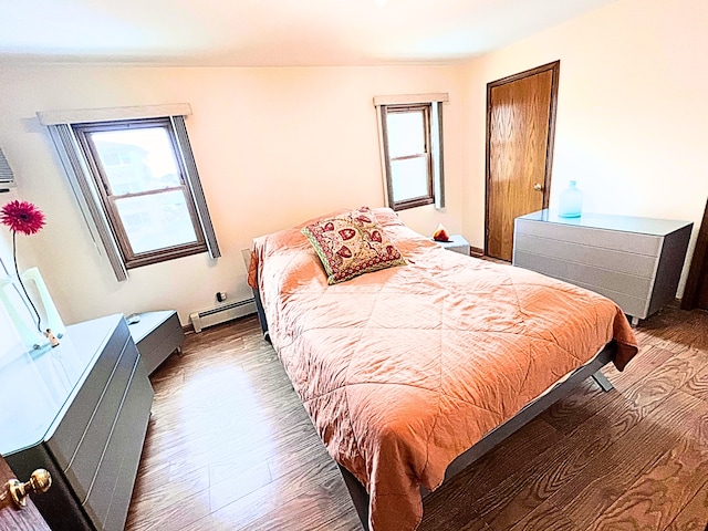 bedroom with dark hardwood / wood-style floors and baseboard heating