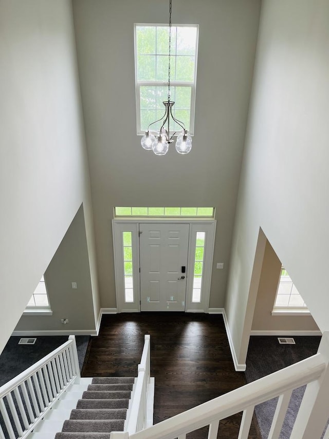 entryway featuring a high ceiling, an inviting chandelier, and a healthy amount of sunlight