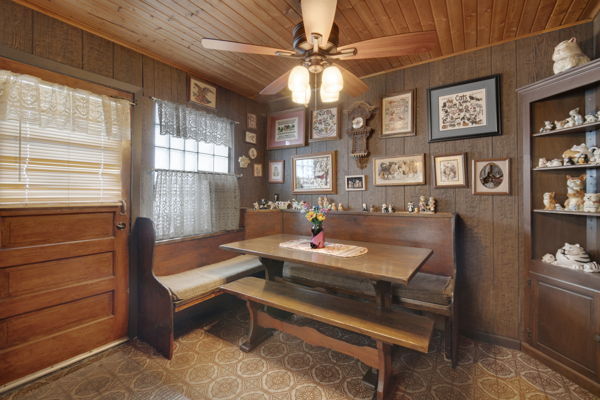 dining room featuring ceiling fan, breakfast area, wood ceiling, and wood walls