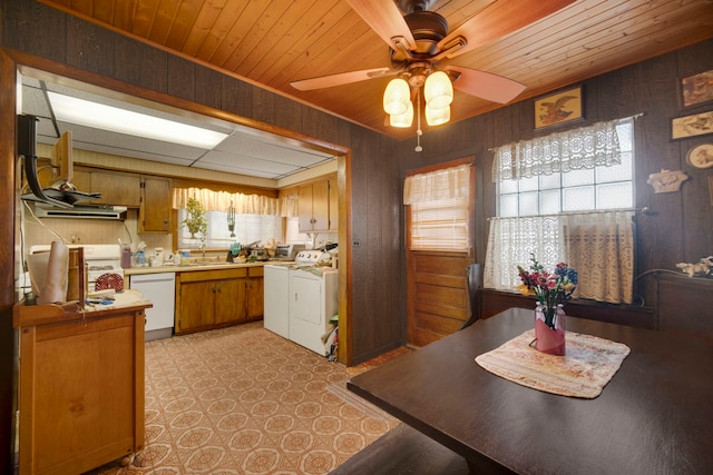 dining area with ceiling fan, wood walls, wooden ceiling, and washing machine and clothes dryer