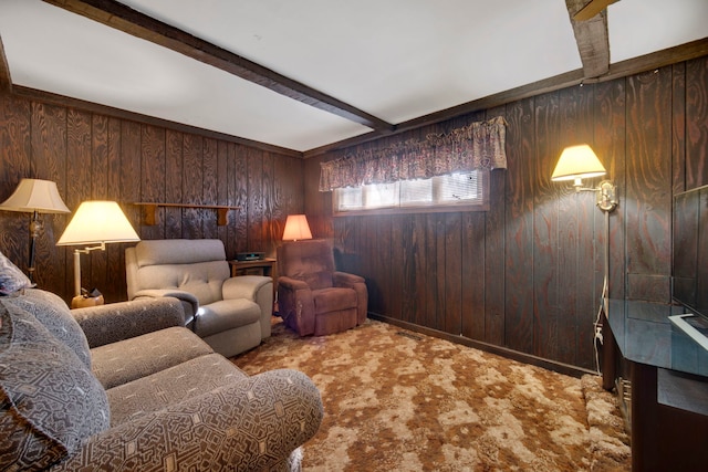 carpeted living room with beam ceiling and wood walls