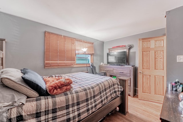 bedroom with lofted ceiling and light wood-type flooring