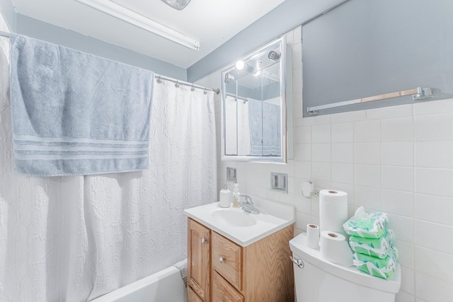 full bathroom featuring vanity, toilet, tile walls, and shower / tub combo