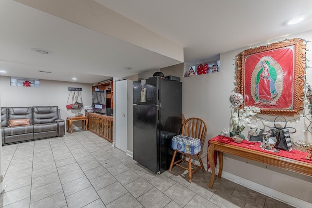 kitchen with light tile patterned floors and black fridge