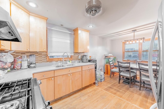 kitchen featuring hanging light fixtures, light brown cabinets, sink, and extractor fan