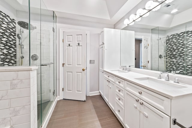 bathroom with a shower with door and vanity