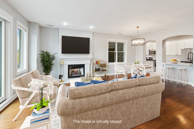 living room with hardwood / wood-style floors and an inviting chandelier