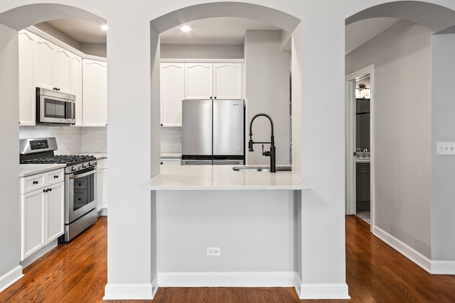 kitchen featuring white cabinets, dark hardwood / wood-style flooring, and stainless steel appliances