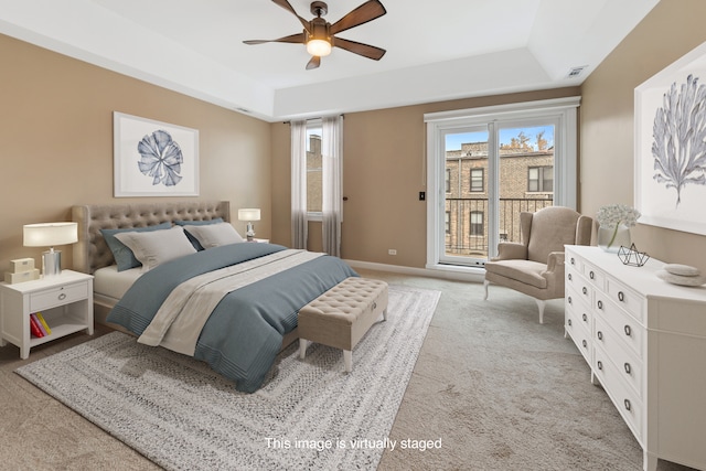 bedroom with light carpet, a raised ceiling, and ceiling fan