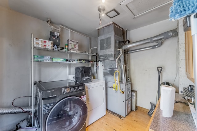 laundry area featuring washing machine and dryer and light hardwood / wood-style flooring