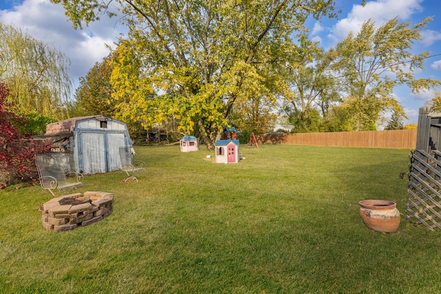 view of yard with a fire pit and a storage unit