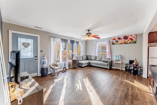 living room with ceiling fan and dark wood-type flooring