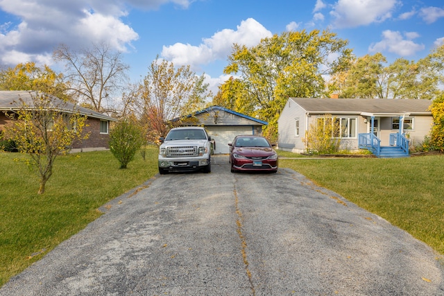 single story home with an outbuilding, a garage, and a front yard