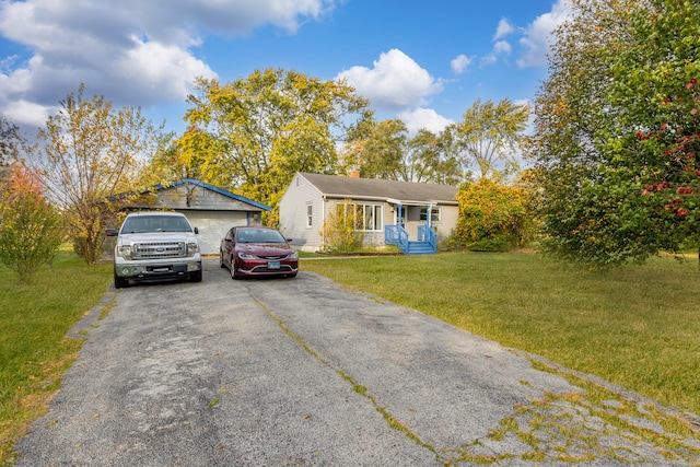 ranch-style house with a garage, an outdoor structure, and a front lawn