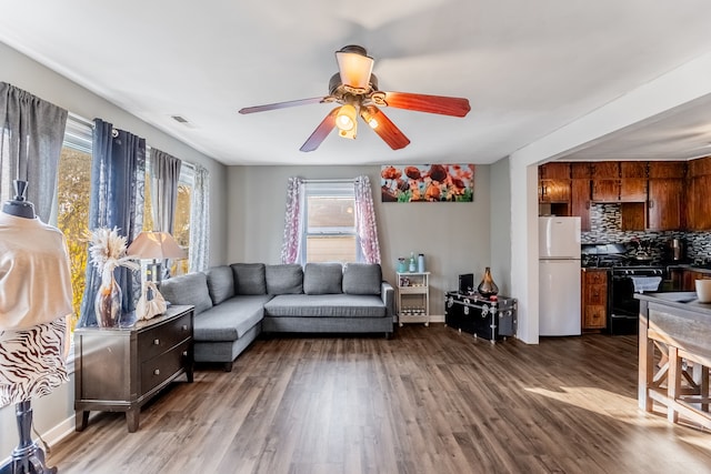 living room featuring ceiling fan and dark wood-type flooring