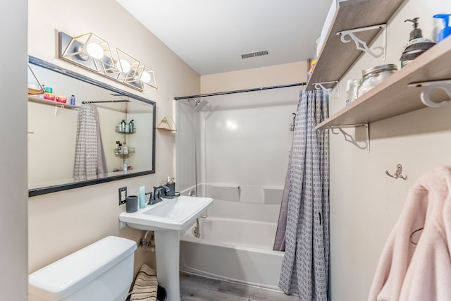 bathroom with wood-type flooring, toilet, and shower / bath combo with shower curtain