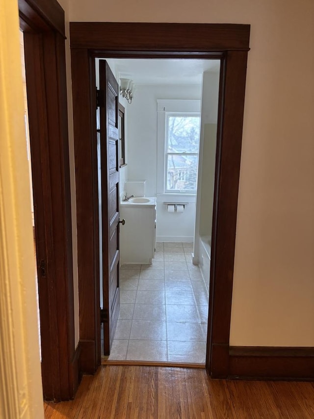 hall with baseboards and light tile patterned floors
