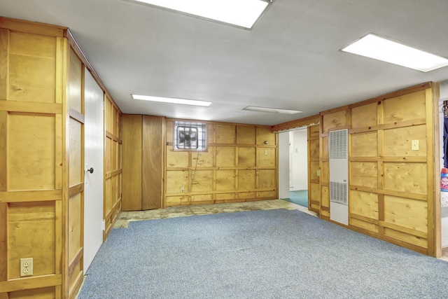 basement featuring light carpet and wood walls