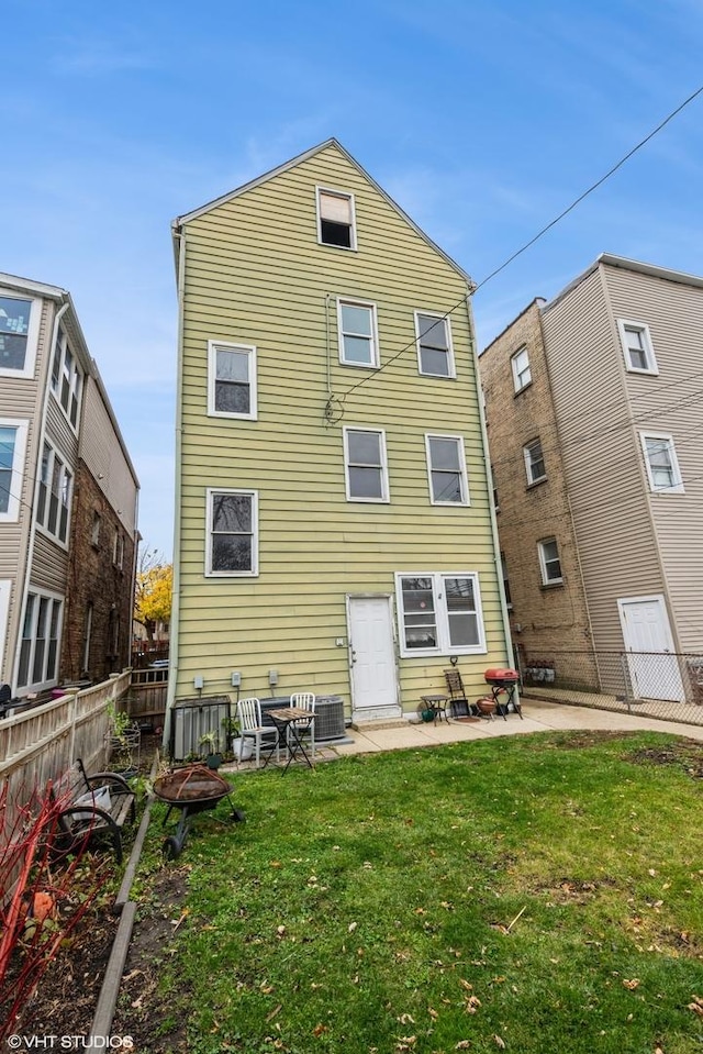 rear view of house featuring a lawn, a patio area, and central AC