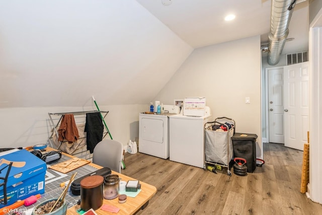 washroom featuring washing machine and dryer and light hardwood / wood-style flooring