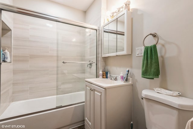 full bathroom with vanity, bath / shower combo with glass door, and toilet