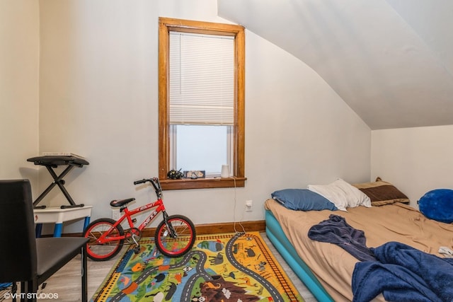 bedroom featuring hardwood / wood-style floors and vaulted ceiling