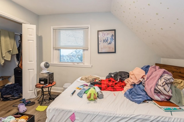 bedroom featuring vaulted ceiling and hardwood / wood-style flooring