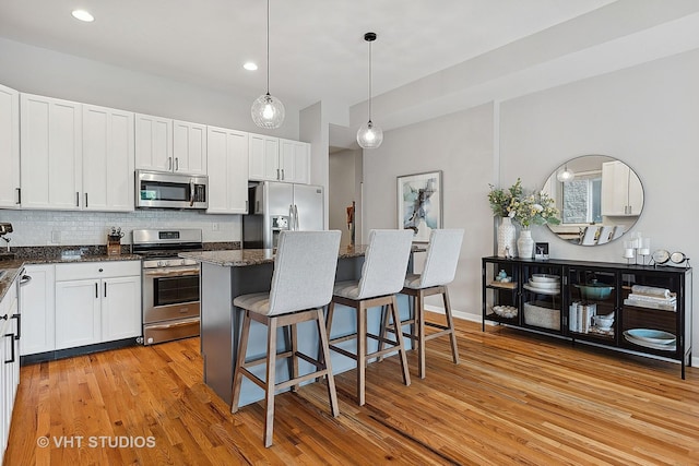 kitchen featuring white cabinets, appliances with stainless steel finishes, and light hardwood / wood-style flooring